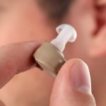 Concept of health care with hearing aid, close up